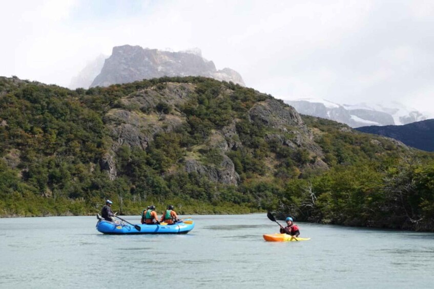 A group of people kayaking on a calm body of water with a mountainous backdrop. 4