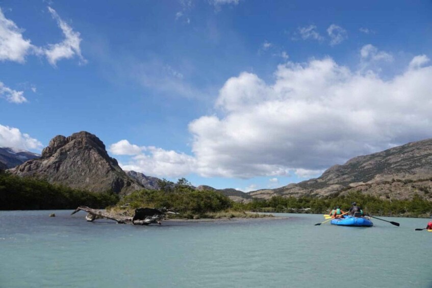 A group of people kayaking on a calm river surrounded by mountains. 1