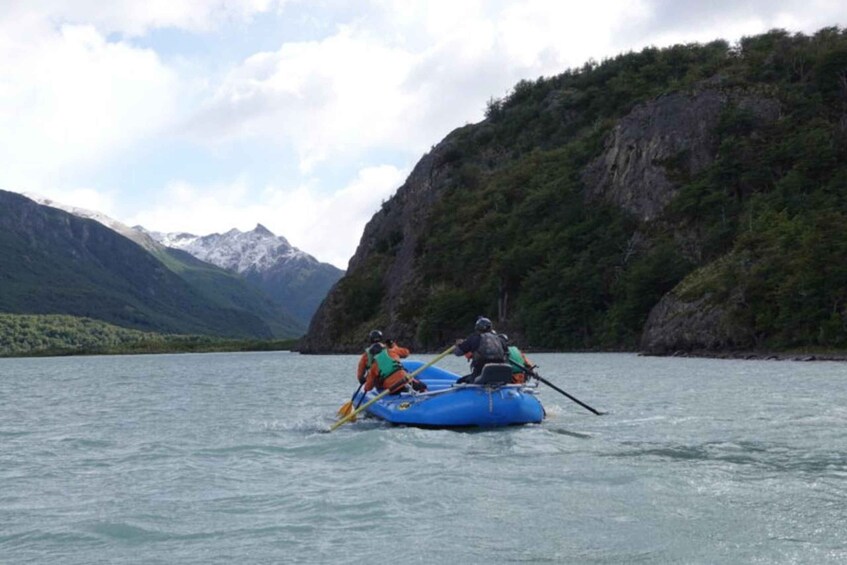 Two people rafting on a river surrounded by mountains. 5