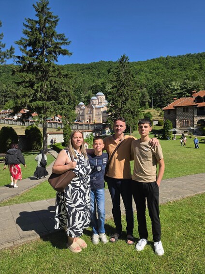 A group of people standing in a park with a historic building in the background. 2