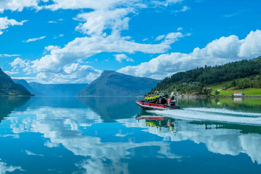 A boat on a calm lake with mountains in the background. 2