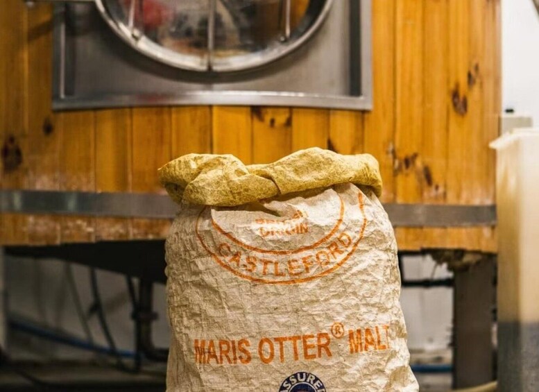 A burlap sack with 'MARIS OTTER MALT' printed on it, placed in a wooden setting. 2
