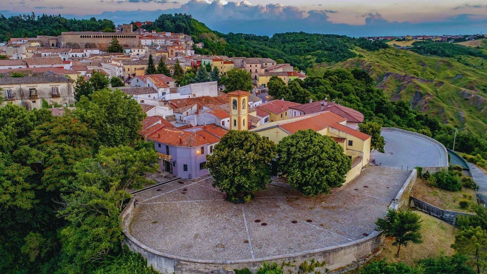 A historic town with a prominent church, surrounded by lush greenery and rolling hills. 4
