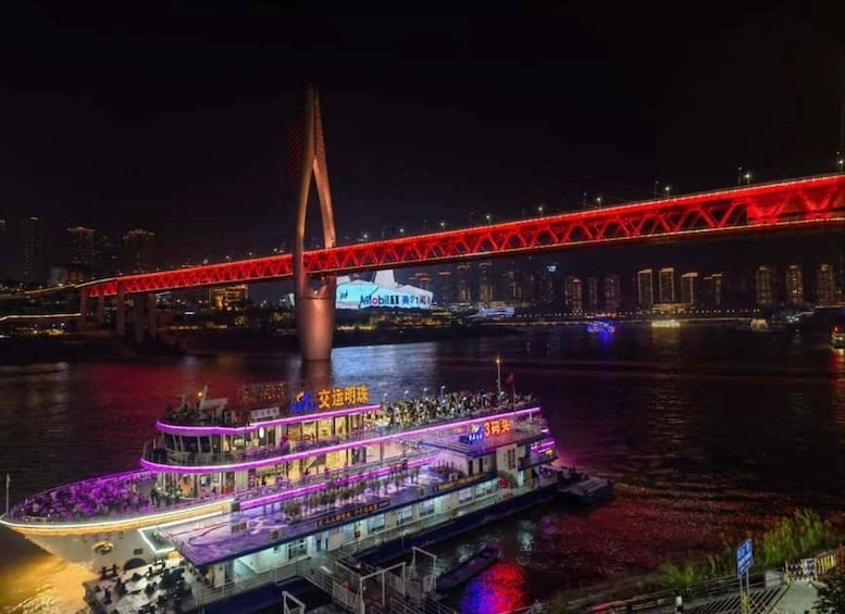 A river with a brightly lit bridge and a boat with purple lighting. 2