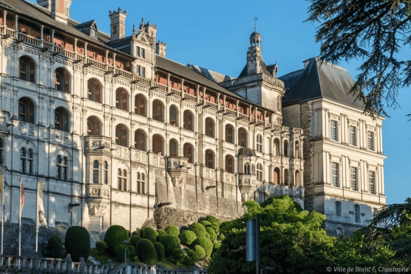 A historic building with classical architecture, featuring arched windows and a symmetrical facade. 3