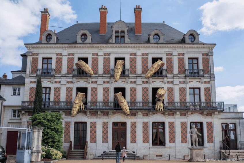 A historic building with ornate balconies and large statues. 2