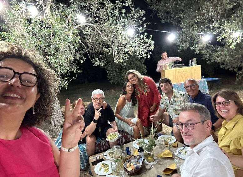 A group of people dining outdoors at night with string lights overhead. 5