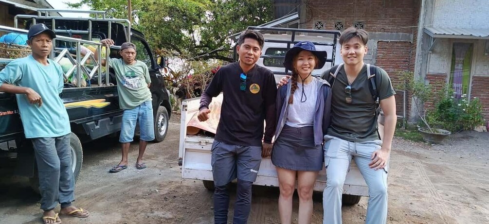A group of people standing in front of a truck with a white box on the back. 2