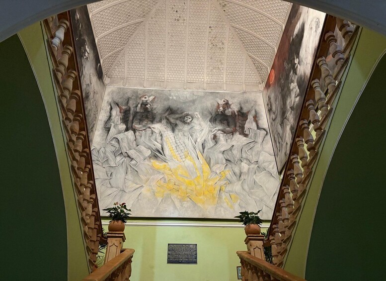 Un escalier orné de balustrades travaillées et une fresque murale. 5