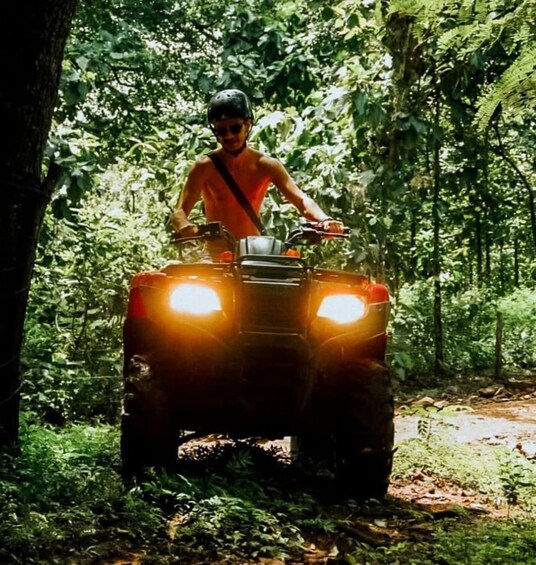 A person riding an ATV in a forested area. 4