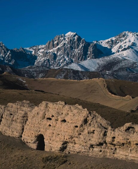A mountainous landscape with snow-capped peaks and a rocky foreground. 5
