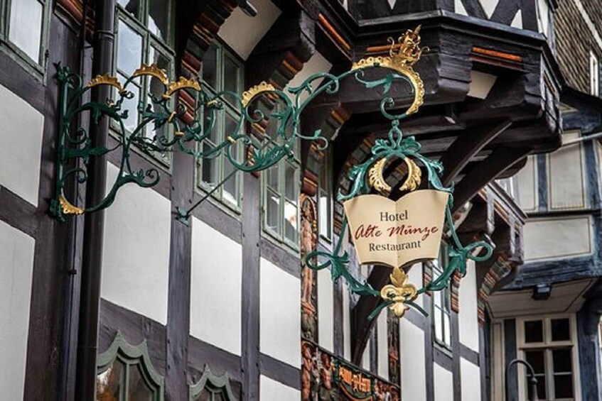 A traditional European building with a sign for 'Hotel Alte Mühle Restaurant' hanging from the corner. 4