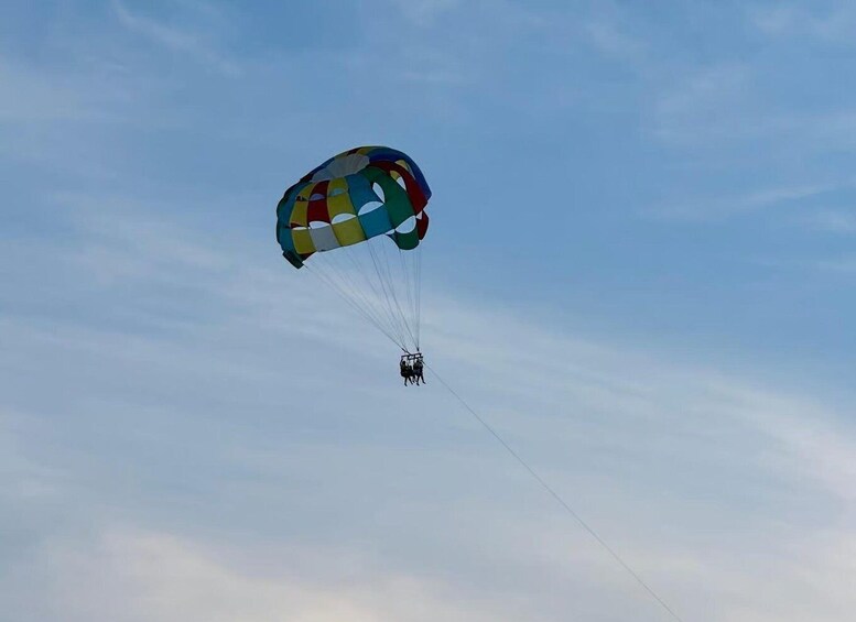 A parachute with multiple colors in the sky. 1