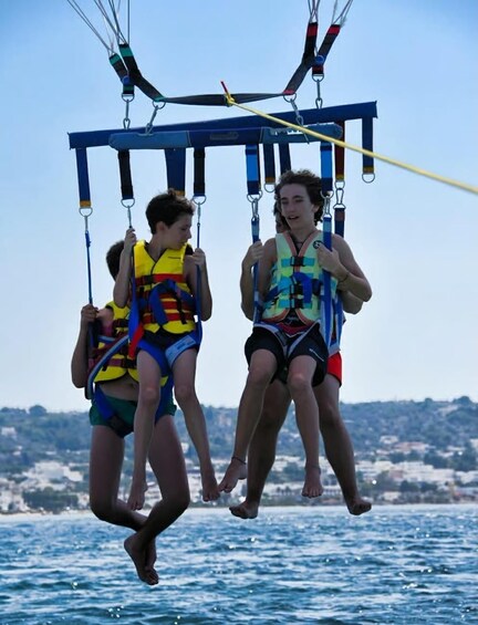 Two people on a swing ride over water with a hilly landscape in the background. 5