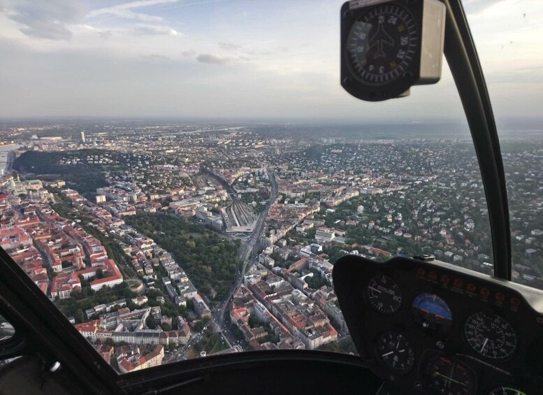 A helicopter cockpit with a view of a city below. 1