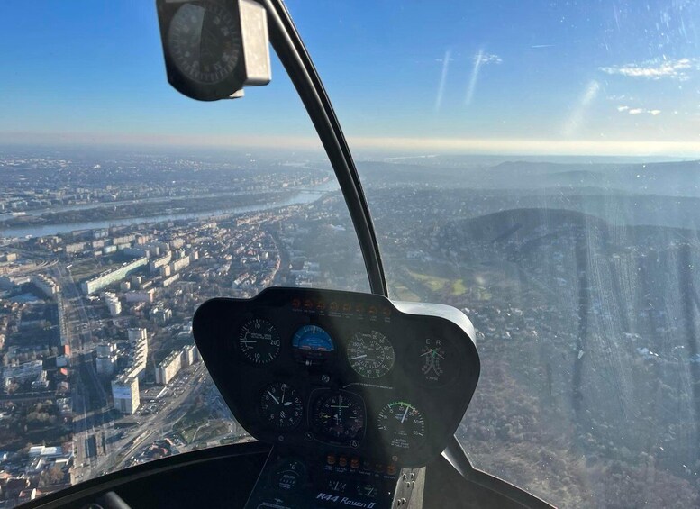 A helicopter cockpit with a view of a cityscape below. 4