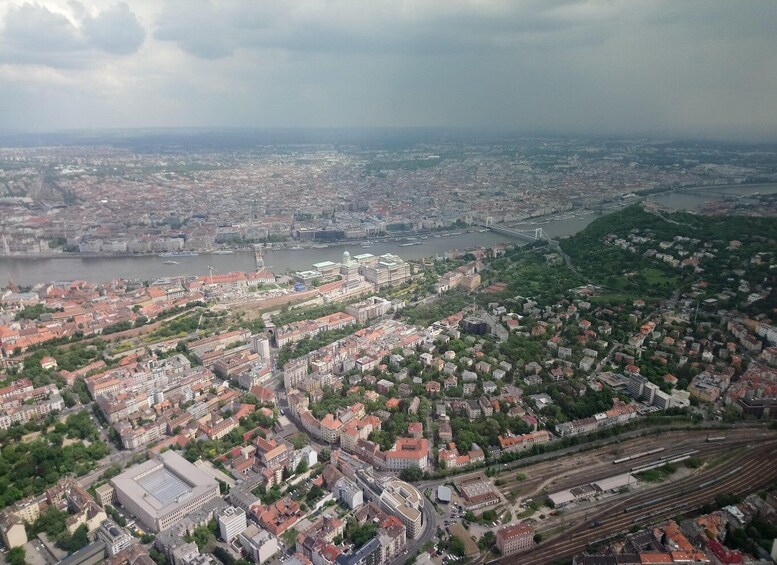 An aerial view of a city with a river, bridges, and a hilly area. 2