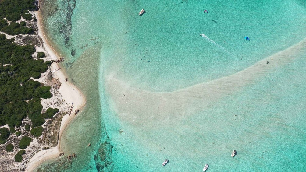 A turquoise coastal area with clear waters, sandy beaches, and boats. 4