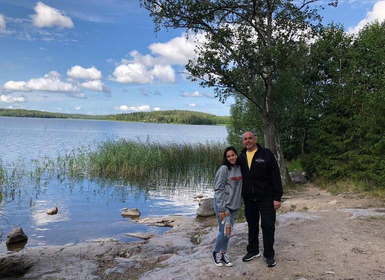 A lake with a rocky shoreline, a tree, and a person standing by the water. 3