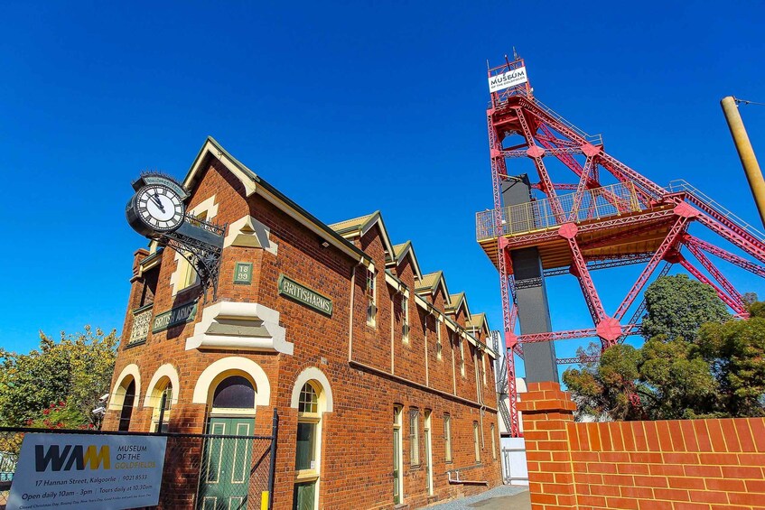 A red-brick building with a clock and signs reading 'BRITISH ARMS' and 'MUSEUM OF THE GOLDFIELDS'. 3