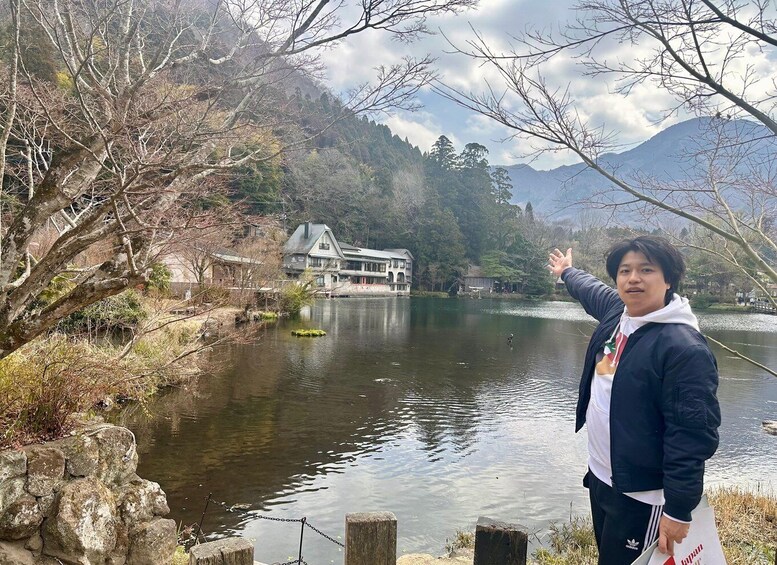 A person pointing at a lake with a house in the background. 4