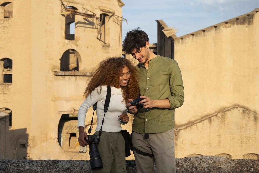 Two people standing on a rooftop with a historic building in the background. 2