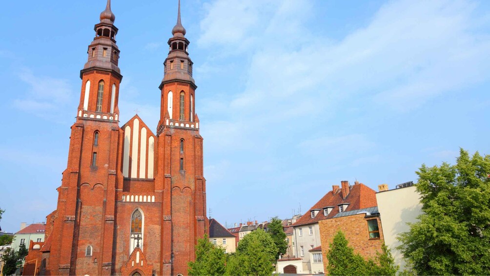 A red brick church with two tall spires and a central tower. 4