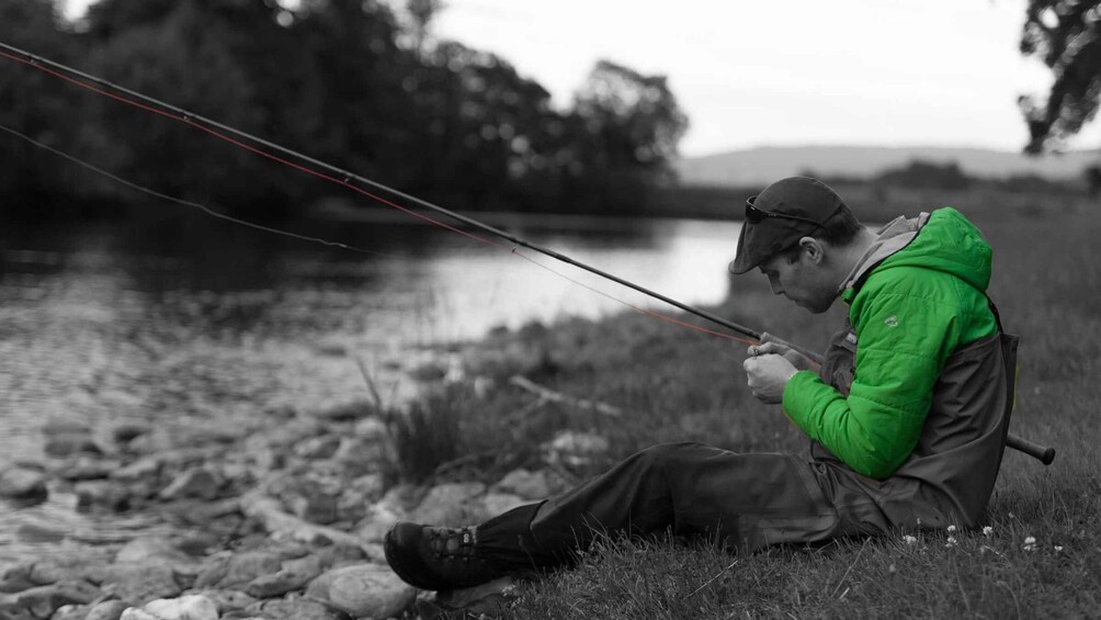 A person fishing by a river. 1