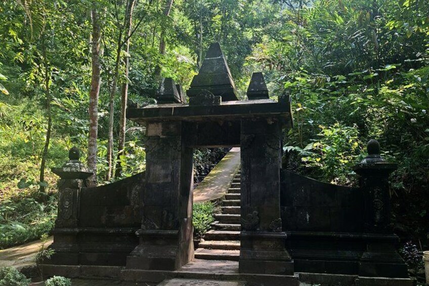 A stone staircase leading up to a traditional gate in a forested area. 5