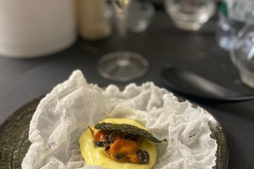 A dish with a creamy sauce and a piece of seafood on a plate. 3