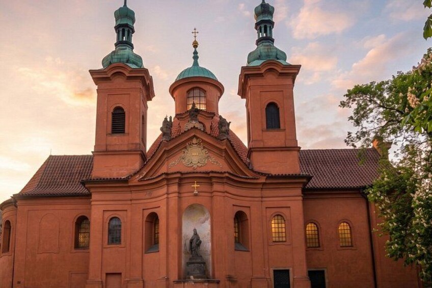 A church with two towers and a central dome, featuring a statue in the entrance. 3