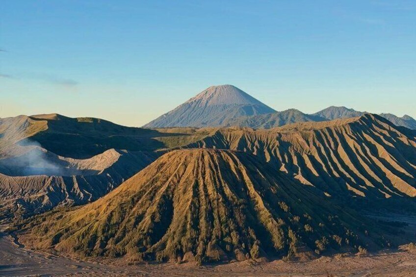 A volcanic landscape with distinct ridges and a prominent mountain in the background. 4