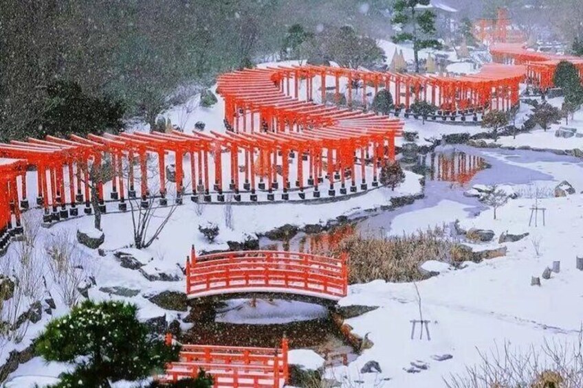 A snow-covered landscape with red torii gates and a small bridge. 4