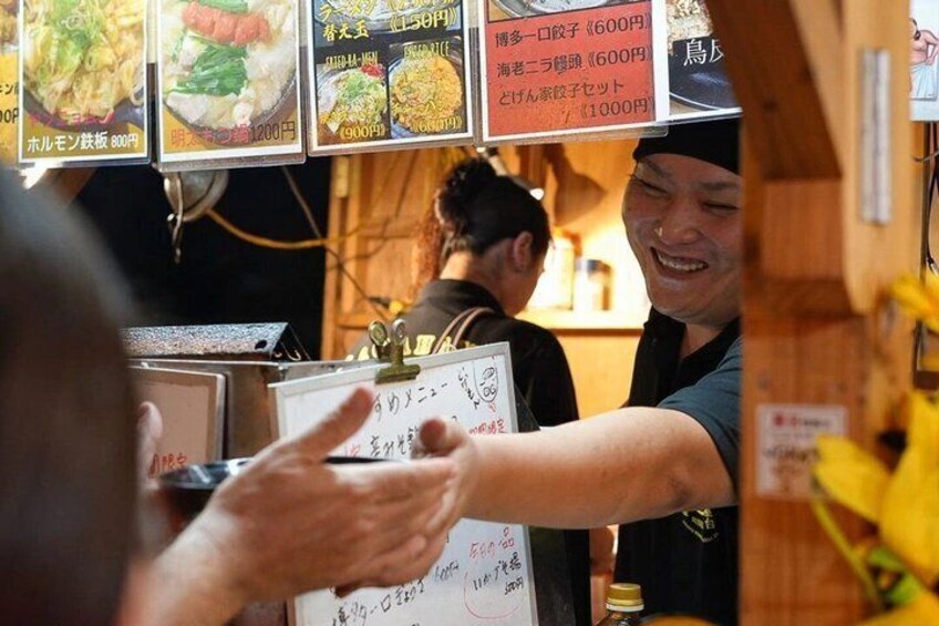 A person handing over a menu to a server. 2