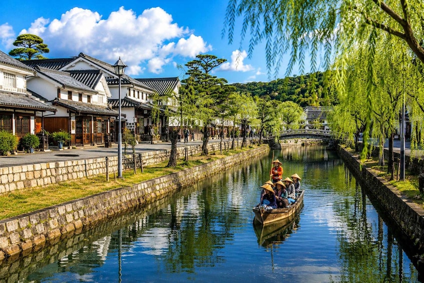 A traditional Japanese town with a canal, wooden houses, and a bridge. 4