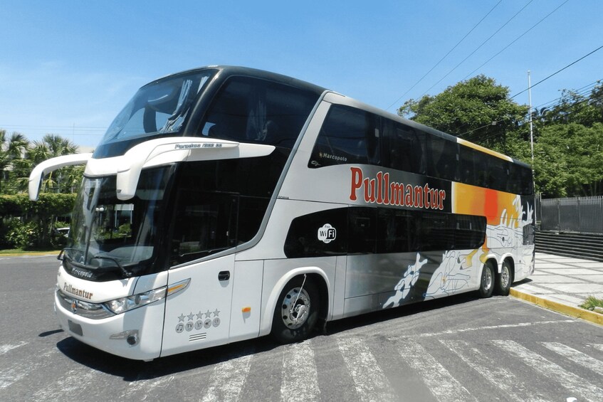 A large double-decker bus with 'Pullman' branding parked on a street. 1