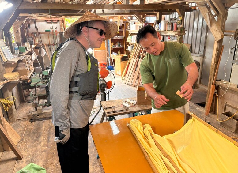 Two people in a workshop with tools and wooden materials. 2