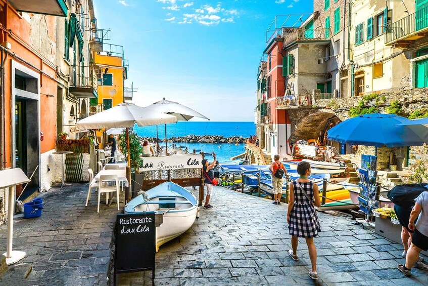 A coastal street with boats, umbrellas, and a restaurant named 'Ristorante da Cila.' 3