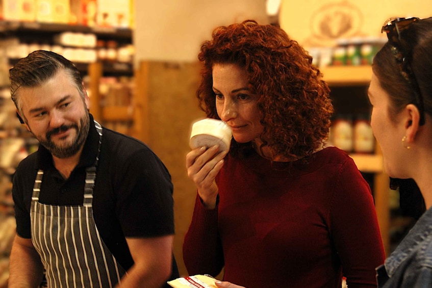 A person holding a cup, another person in a striped apron, and a third person in a red sweater. 1