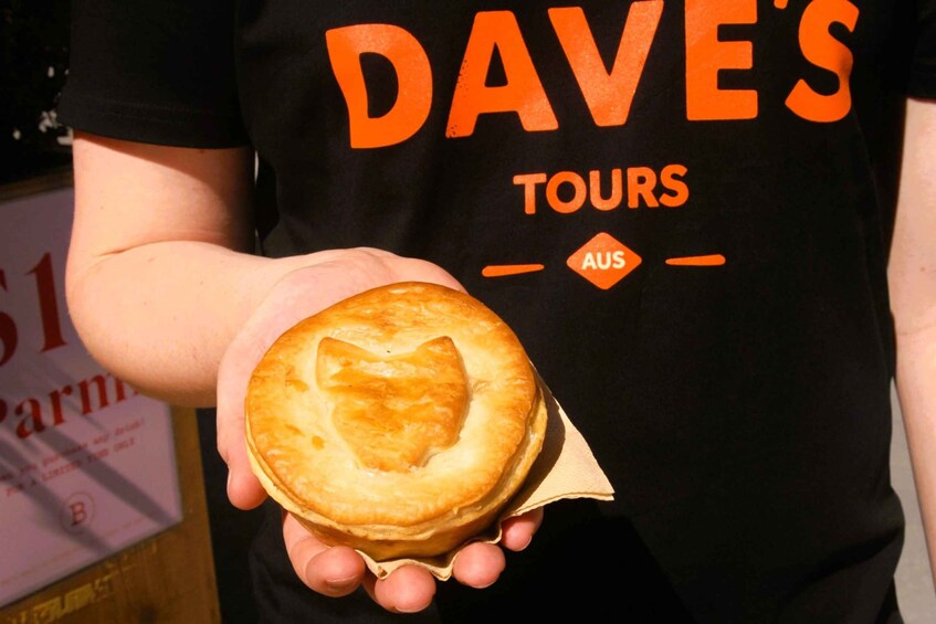 A person holding a round pastry with a heart-shaped cutout in the center. 5