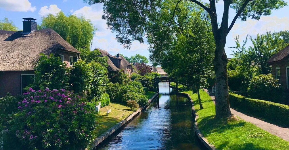 A canal with houses on one side and a bridge in the distance. 4