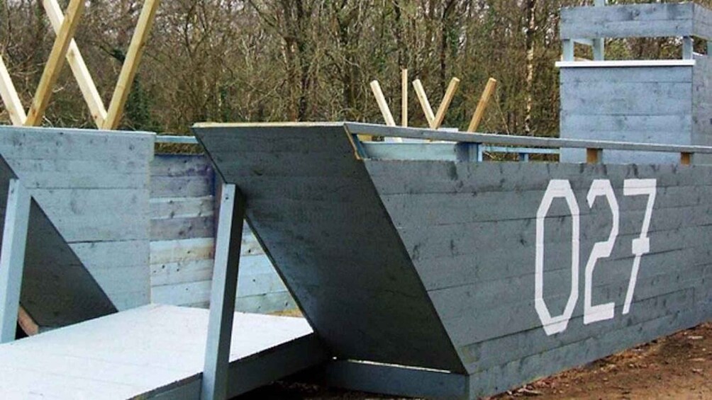 A wooden structure with the number 027 painted on it, surrounded by trees. 1