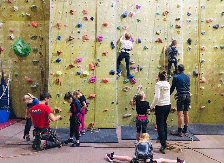 A climbing gym with various colored holds and ropes. 2