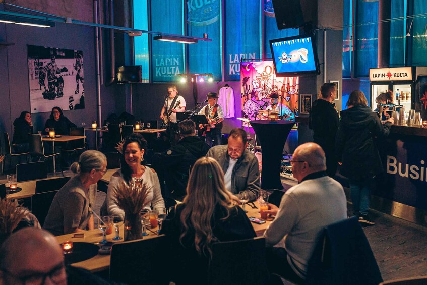 A live music performance in a dimly lit venue with patrons seated at tables. 2