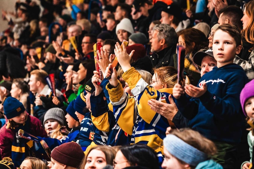A crowd of people at an event, some wearing yellow and blue jackets. 2