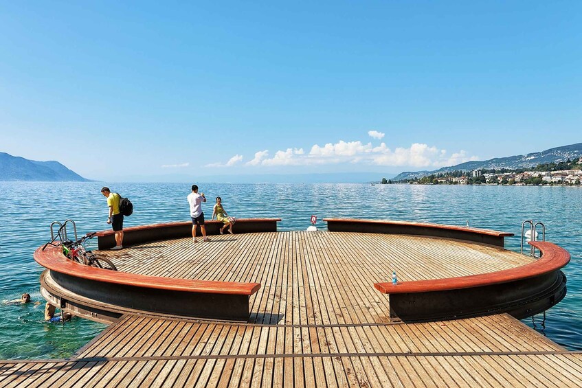 A wooden pier extending into a calm lake with a clear sky. 2