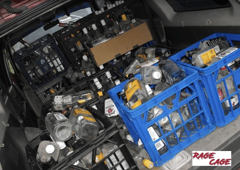 A car trunk filled with various items including bottles, containers, and a cardboard box. 3