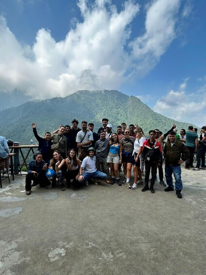 A group of people posing in front of a mountainous landscape. 1