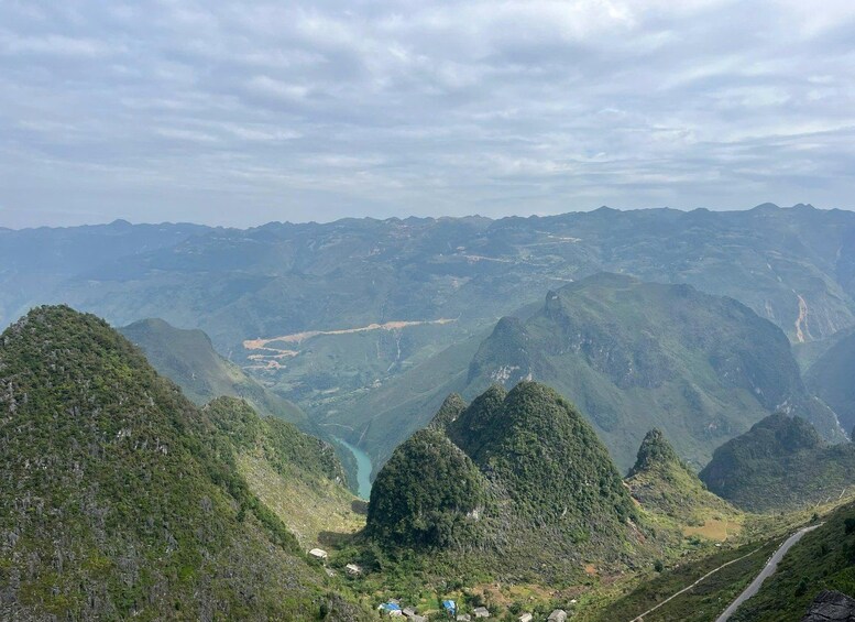 A mountainous landscape with a winding road, green valleys, and a river. 4