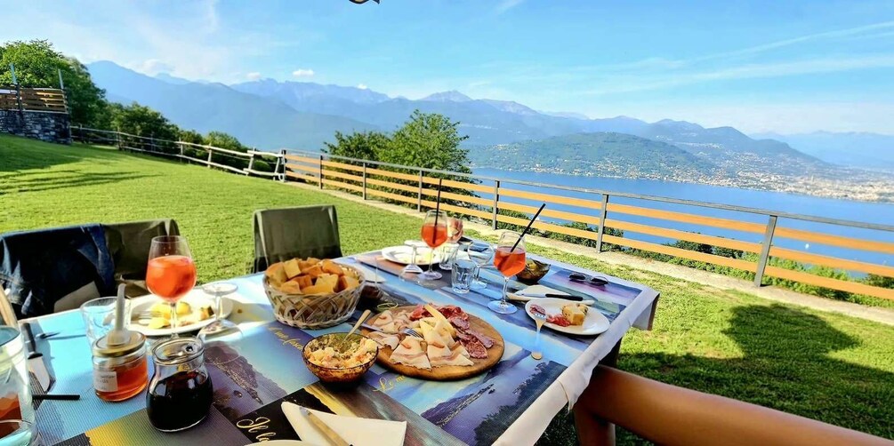 A table set outdoors with food and drinks, overlooking a scenic mountain view. 3